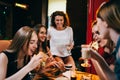 Group of young girlfriends having lunch in fast food restaurant eating craft hamburgers Royalty Free Stock Photo