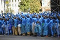 Group of young girls and boys coloured in blue like Avatars standing in the middle of the street and waving hands.