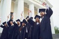 A group of graduate students raised their hands with diplomas up Royalty Free Stock Photo