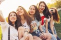 Group of young happy carefree girls friends making selfie on summer city street, sunset time background