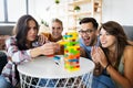 Group of young happy friends having fun playing wood board game Royalty Free Stock Photo