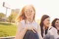 Group of young happy girls friends enjoy life on summer city street, sunset background