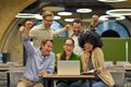 Group of young happy multiracial business people sitting at desk in the modern office or coworking space, looking at Royalty Free Stock Photo