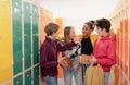 Group of young high school students standing near locker in campus hallway talking during break. Royalty Free Stock Photo