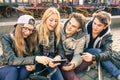 Group of young hipster friends having fun with smartphones