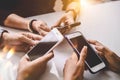 Group of young hipsters holding mobile phones in hands at office. Friends having fun together with smartphone. Technology and