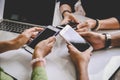 Group of young hipsters holding mobile phones in hands at office with laptop computer background. Friends having fun together with Royalty Free Stock Photo