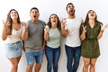 Group of young hispanic friends standing together over isolated background crazy and mad shouting and yelling with aggressive Royalty Free Stock Photo