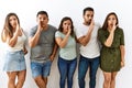 Group of young hispanic friends standing together over isolated background hand on mouth telling secret rumor, whispering Royalty Free Stock Photo