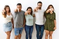 Group of young hispanic friends standing together over isolated background looking unhappy and angry showing rejection and Royalty Free Stock Photo