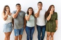 Group of young hispanic friends standing together over isolated background shocked covering mouth with hands for mistake Royalty Free Stock Photo