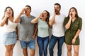 Group of young hispanic friends standing together over isolated background shouting and screaming loud to side with hand on mouth Royalty Free Stock Photo