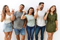 Group of young hispanic friends standing together over isolated background smiling looking to the camera showing fingers doing Royalty Free Stock Photo