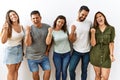 Group of young hispanic friends standing together over isolated background very happy and excited doing winner gesture with arms Royalty Free Stock Photo