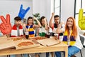 Group of young hispanic people eating pizza supporting soccer team at home annoyed and frustrated shouting with anger, yelling Royalty Free Stock Photo