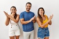 Group of young hispanic people standing over isolated background clapping and applauding happy and joyful, smiling proud hands Royalty Free Stock Photo