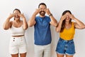 Group of young hispanic people standing over isolated background covering eyes with hands smiling cheerful and funny Royalty Free Stock Photo