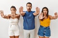 Group of young hispanic people standing over isolated background doing stop gesture with hands palms, angry and frustration Royalty Free Stock Photo