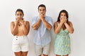 Group of young hispanic people standing over isolated background shocked covering mouth with hands for mistake Royalty Free Stock Photo