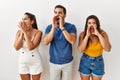 Group of young hispanic people standing over isolated background shouting angry out loud with hands over mouth Royalty Free Stock Photo