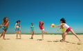 Group of young joyful girls playing volleyball