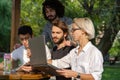 A group of young laptops working in the park.