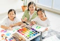 group of young and little children and teacher happy, look at camera, painting color, select focus at young child. asian beautiful