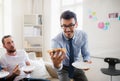 Group of young male businesspeople having lunch in a modern office. Royalty Free Stock Photo