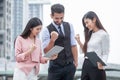 group of young man and women friends using a tablet and laughing outdoors .three people of teamwork exciting business online of Royalty Free Stock Photo