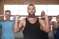 Group of Young Men in Gym Training With Barbells. Royalty Free Stock Photo