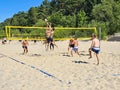 A group of young men playing beach volleyball on the sand in the dune zone Royalty Free Stock Photo