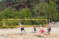 A group of young men playing beach volleyball on the sand in the dune zone near the Baltic Sea