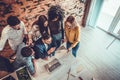 Group of young modern people in smart casual wear having a brainstorm meeting while standing behind the laptop in the creative Royalty Free Stock Photo