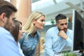 Group of young modern people in smart casual wear having a brainstorm meeting while standing in the creative office. Royalty Free Stock Photo