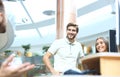 Group of young modern people in smart casual wear having a brainstorm meeting while standing in the creative office. Royalty Free Stock Photo