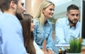 Group of young modern people in smart casual wear having a brainstorm meeting while standing in the creative office. Royalty Free Stock Photo