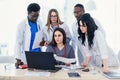 Group of young multi national doctors during working with laptop in the conference room. Royalty Free Stock Photo