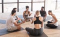 Group of young multiethnic people in sportswear having rest after yoga training Royalty Free Stock Photo