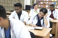 A group of young multiethnic races, medical students. Read textbooks while sitting at a desk. Dullness of exams, study Royalty Free Stock Photo