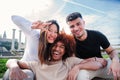 Group of young multiracial friends hugging and having fun together. Three happy cool buddies smiling and looking at Royalty Free Stock Photo