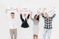 Group of young multiracial people posing together for protesting demonstration, holding posters with antiwar, justice