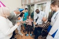 A group of young and old people in a nursing home congratulate an elderly woman on her birthday. Royalty Free Stock Photo
