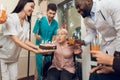 A group of young and old people in a nursing home congratulate an elderly woman on her birthday. Royalty Free Stock Photo