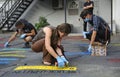 Group of young people activists painting offensive lettering against politicians Putin and Medvedchuk with spray cans on