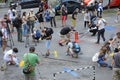 Group of young people activists painting offensive lettering against Putin on asphalt, cameramen shooting. Kyiv, Ukraine