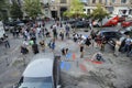 Group of young people activists painting offensive lettering against Putin on asphalt, cameramen shooting. Kyiv, Ukraine