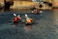Kayaks on the river. A group of young people canoeing on a city river Royalty Free Stock Photo