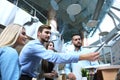 Group of young people in casual wear sitting at the office desk and discussing something while looking at PC together. Royalty Free Stock Photo