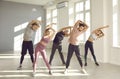 Group of young people doing exercise during a fitness workout with a sports instructor