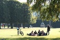 A group of young people enjoy the European sun and sit on the lawn in the park